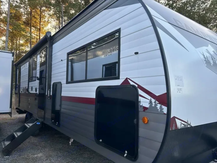 This white and gray travel trailer RV rental is parked outdoors with steps extended, ready for adventure.. Forest River Campsite Reserve 2026