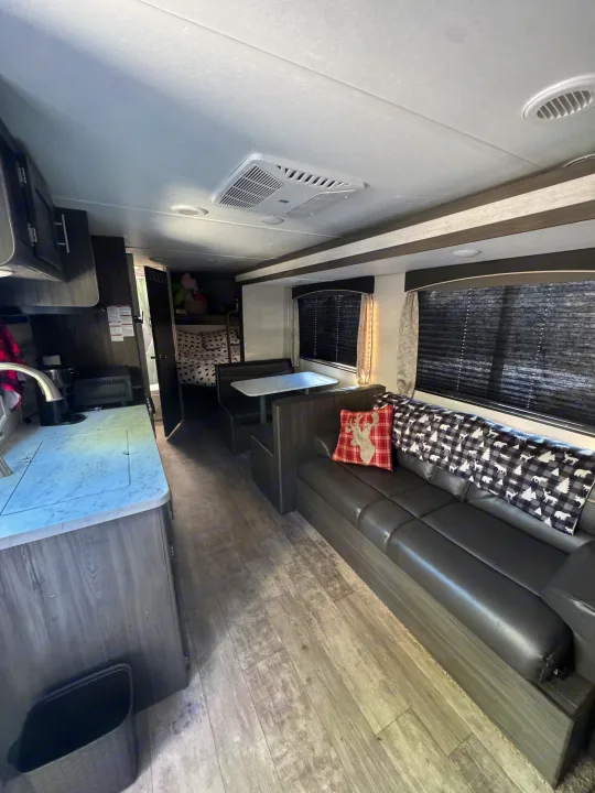 Spacious RV rental interior: kitchen, dinette, cozy sofa, and bunks in a modern travel trailer layout.. Forest River Shasta 2021