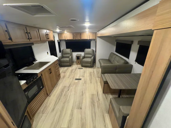 Spacious RV rental interior featuring a modern kitchen, living area with recliners, and a cozy dinette.. Keystone RV Other 2026