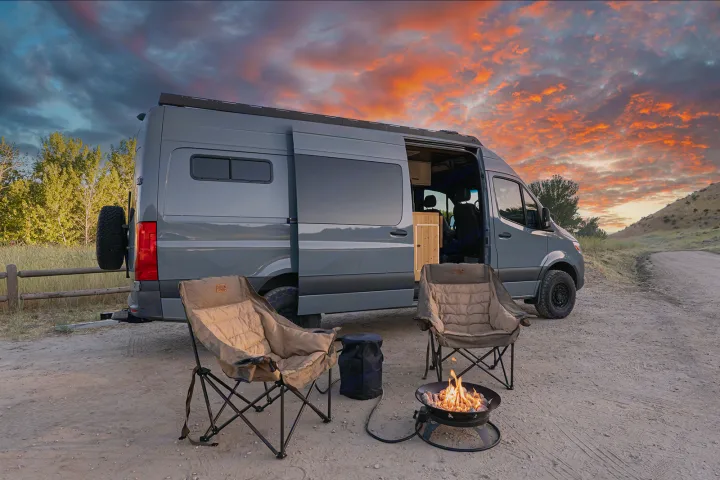 Gray camper van RV rental, cozy camping chairs, & fire pit under a vibrant sky. Your ultimate outdoor adventure awaits!. MERCEDES-BENZ SPRINTER 2500 170 WB 2022