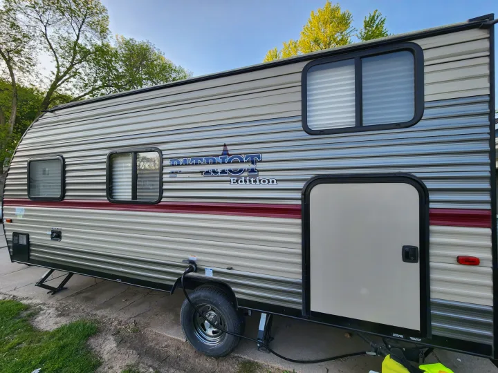 Patriot Edition RV rental side view, plugged in with stabilizing jacks, ready for your next travel adventure.. Forest River Cherokee Wolf Pup 2018