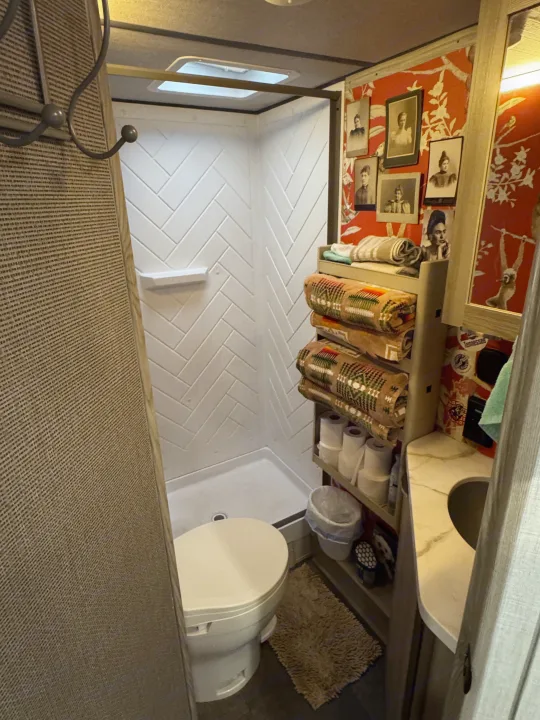 Cozy RV rental bathroom with a shower, toilet, sink, and smart storage for towels & toiletries. Unique decor adds charm.. Forest River Salem FSX 2025