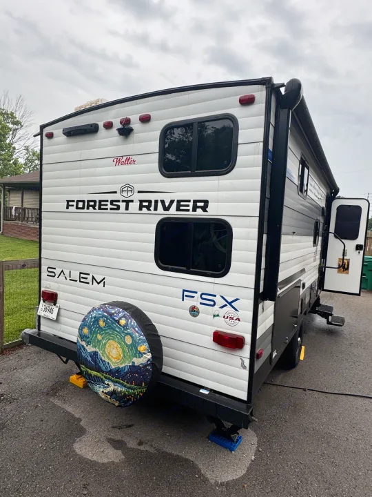 Rear view of a white Forest River Salem FSX RV rental, with a unique 'Starry Night' spare tire cover, parked outside.. Forest River Salem FSX 2025