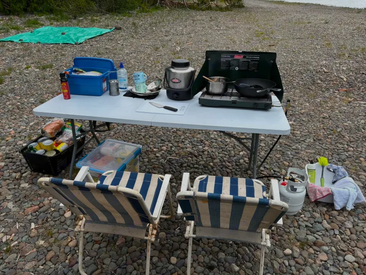 RV rental guests can enjoy this complete outdoor kitchen & dining setup with stove, table, and chairs on a rocky shore.. chevy uplander 2006
