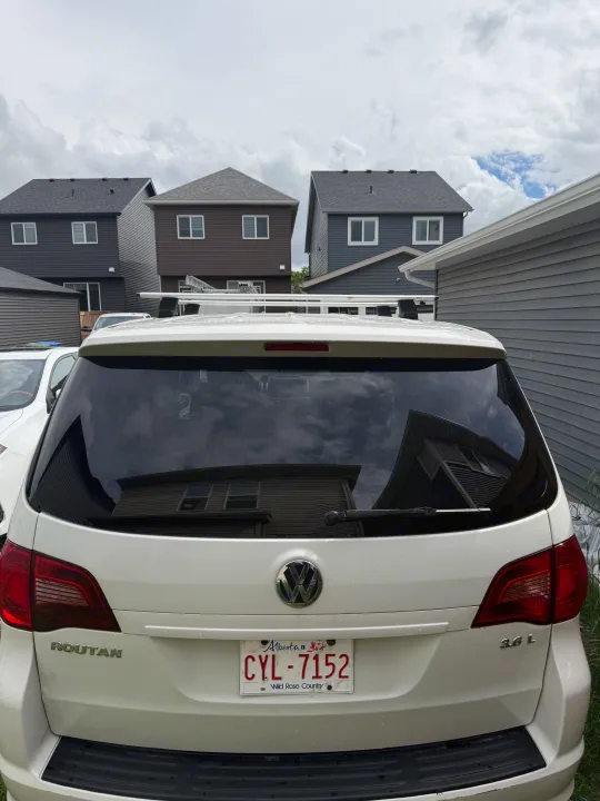 Rear of a white Volkswagen Routan minivan (Alberta license CYL-7152) with a roof rack, useful for road trips or as an rv rental alternative.. Volkswagen Routan 2011