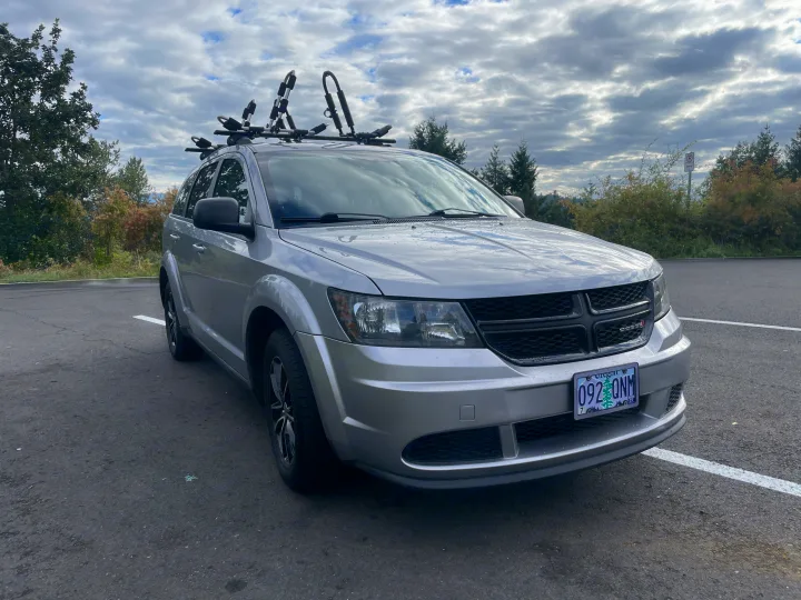 This silver Dodge Journey SUV with kayak rack is ready for adventure. For larger trips, explore an RV rental option.. Dodge Journey 2017