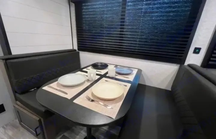 Enjoy meals in this RV rental dinette! Features comfortable booth seating, a well-set table, and dark window blinds.. Jayco Jay Flight 2024
