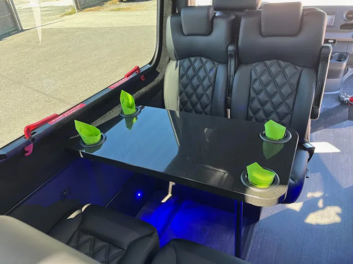 Luxury rv rental interior: Comfortable seating, sleek table with green napkins & blue LED lighting. Perfect for travel.. Forest River 2025