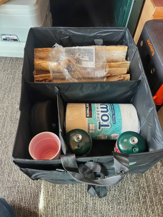 RV rental prep: Firewood, paper towels, propane, and camping gear neatly organized in a tote, ready for adventure!. Ford Econolline 250s 2006