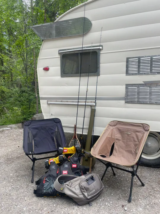 RV rental with fishing rods, Helinox chairs, Helly Hansen PFDs, and Orvis gear, ready for a camp and fish outing.. Shasta Airflyte 1958