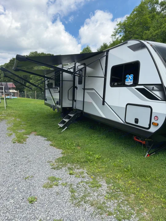 This white and gray travel trailer (RV) with an extended awning and steps is ready for your next rv rental adventure.. Jayco Eagle HT 2025