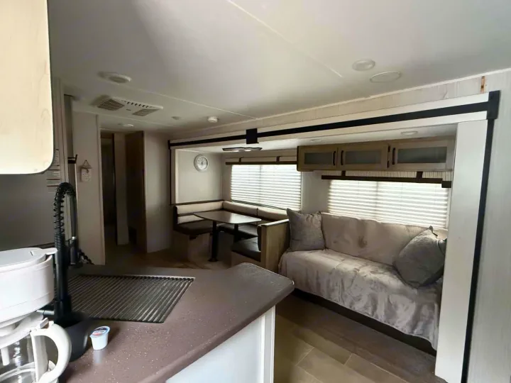 Spacious rv rental interior showing kitchen, dinette seating, and sofa lounge area.. Forest River Palomino Puma XLE Lite 2021