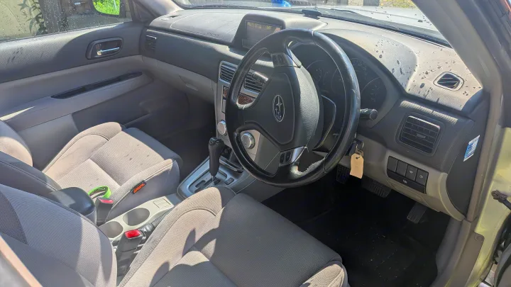 Car interior with dashboard, steering wheel, seats. Evaluate vehicle readiness for RV rental services.. Subaru Forester 2009