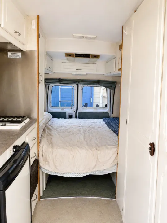 Cozy rv rental interior: compact kitchen to left, comfortable bed at rear, ready for adventure.. Pleasure-Way Pleasure-Way Class B 2002