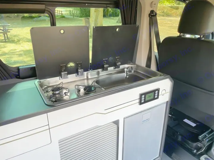 RV rental interior: compact kitchenette featuring a 2-burner stove, sink, fridge, and digital control panel.. HANROAD TREK 5 2026