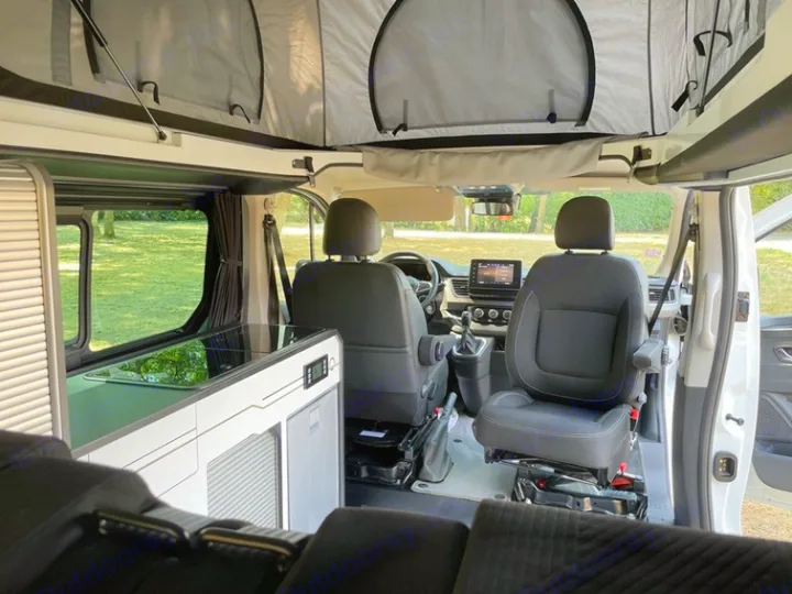 Inside an RV rental: a camper van interior featuring a pop-top roof, integrated kitchenette, and swiveling front seats.. HANROAD TREK 5 2026