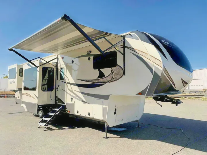 This beautiful Solitude fifth-wheel RV rental is ready for adventure, featuring an extended awning, slide-outs, and steps.. Grand Design Solitude 2018