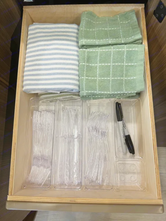 RV rental drawer organized with kitchen towels, clear disposable forks, spoons, and a Sharpie marker.. Forest River Wildwood FSX Platinum 2026