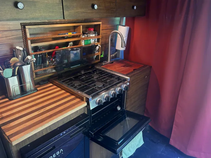 Enjoy this RV rental's compact kitchen with gas stove/oven, sink, wood counters, & smart storage for your adventures on the road.. RAM Promaster 2022