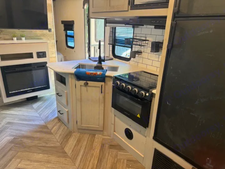 Modern rv rental with bright kitchen, full-size stove, fridge, and cozy fireplace living area. Your comfy home on wheels.. Heartland RVs Mallard 2023