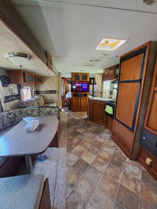 Spacious rv rental interior: kitchen, dinette, living area with TV, and bedroom for comfortable travel.. Keystone RV Passport Ultra Lite 2012