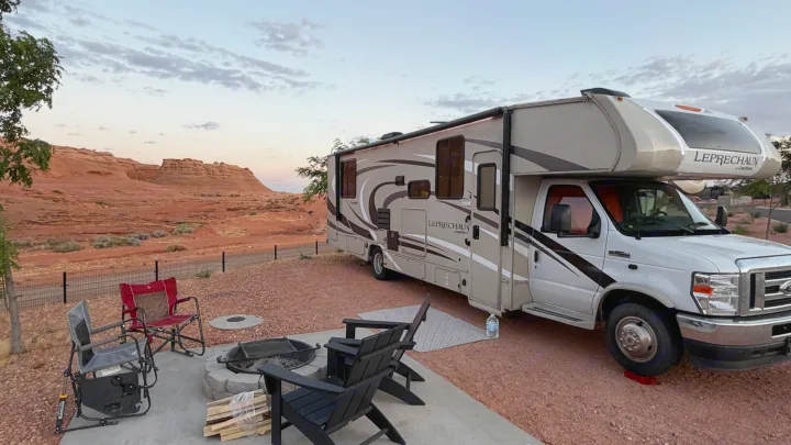Relaxing at a desert campsite with an rv rental. Fire pit and stunning red rock views create a perfect outdoor getaway.. Coachmen Leprechaun 2021