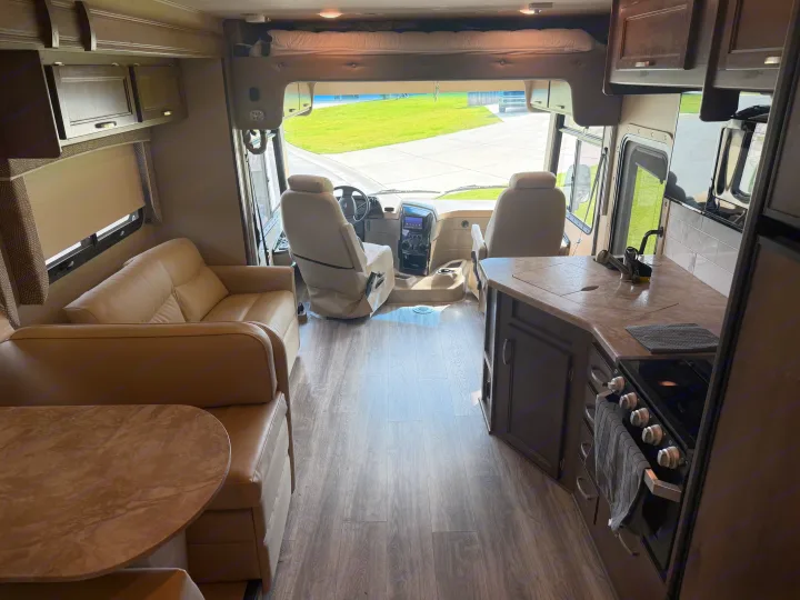 Spacious RV rental interior: modern kitchen, cozy living area, driver's cockpit, and comfy bunk bed for your travels.. Entegra Coach Vision 2020