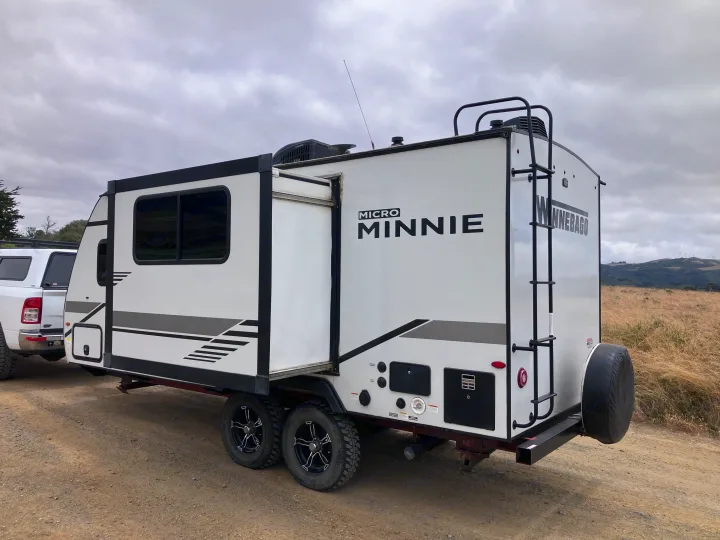 RV rental: Winnebago Micro Minnie travel trailer with slide-out extended, parked on a dirt road for adventure.. Winnebago Micro Winnie 2021