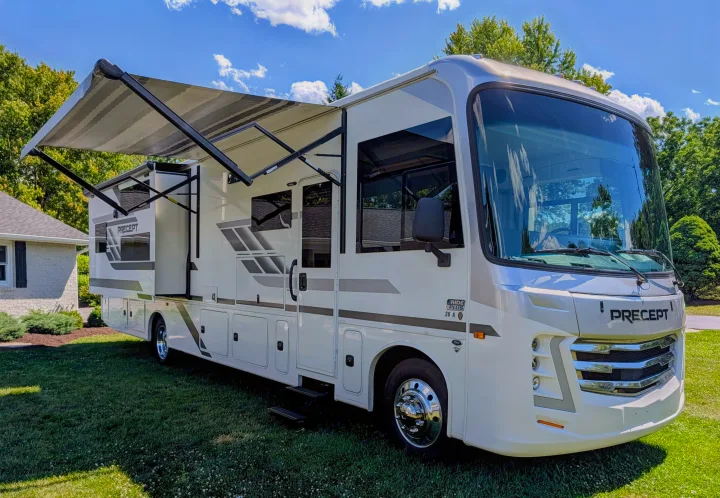 Jayco Precept Class A RV rental on a sunny day, with its awning and slide-out extended on a green lawn.. Jayco Precept 2025
