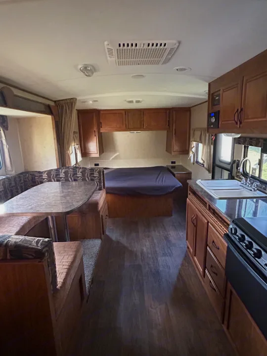 Cozy RV rental interior featuring a dinette, bed, and full kitchen, perfect for your next road trip adventure.. Outdoors RV 22BHS 2019