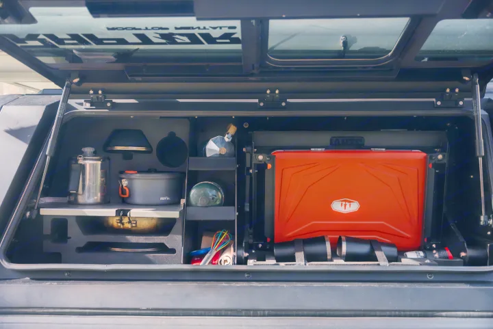 Organized outdoor kitchen setup for an rv rental: stove, pots, & coffee maker neatly stored in a truck bed compartment.. Ford Ford F150 2026