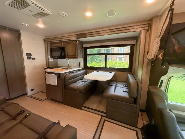 Cozy RV rental interior with full kitchen, comfy dinette seating, and living space. Ready for your next road trip!. Entegra Coach Odyssey 2023