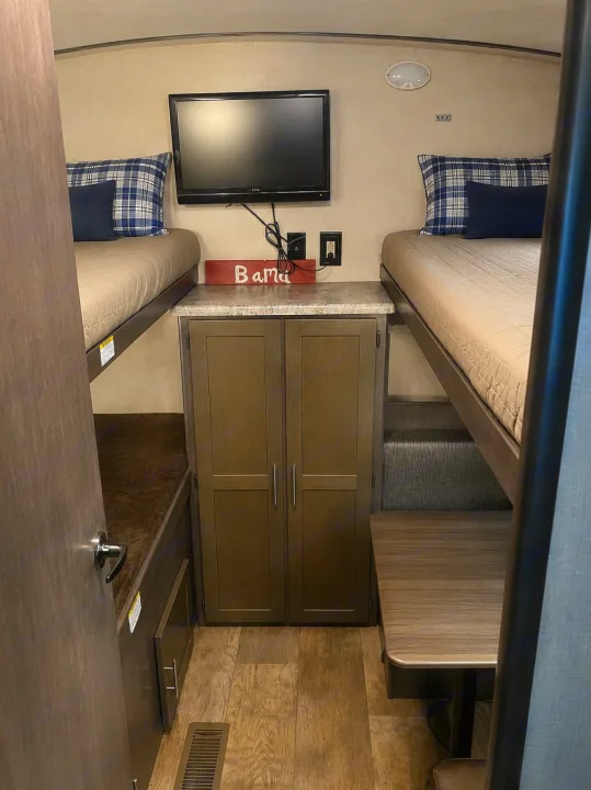 This RV rental features a cozy bunk room with twin bunk beds, a TV, storage, and dinette seating. Great for family trips!. CrossRoads RV Sunset Trail Super Lite 2016