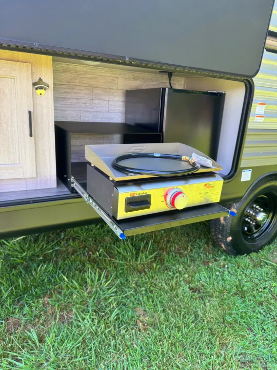 Enjoy an RV rental's outdoor kitchen, featuring a pull-out gas griddle, mini-fridge, and bottle opener.. Forest River Aurora Aurora Light 2026