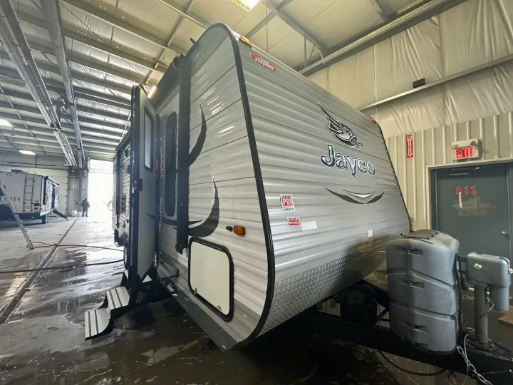 Jayco Four Seasons rv rental travel trailer, recently winterized and serviced indoors. Wet floor visible from maintenance.. Jayco Jay Flight 2015