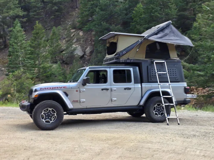 Jeep Gladiator Mojave with overland rooftop tent setup. An adventure RV rental for off-road camping in the wilderness.. jeep Gladiator 2021