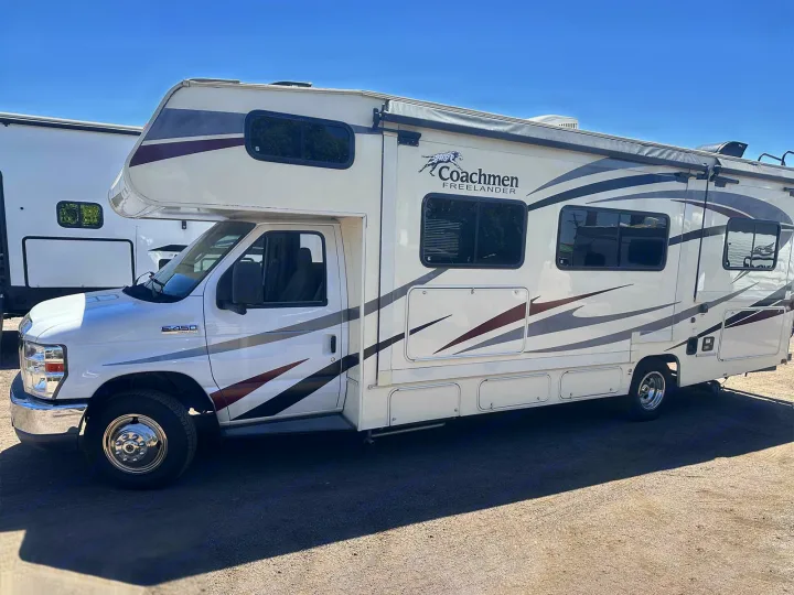 A white Coachmen Freelander RV rental with distinctive graphics, parked outdoors on a sunny day.. Coachmen Freelander 2018
