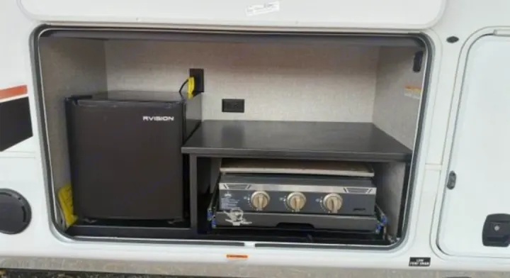 This RV rental features a convenient outdoor kitchen with a mini-fridge, pull-out stovetop/grill, and power outlets for camping.. Jayco North Point 2023