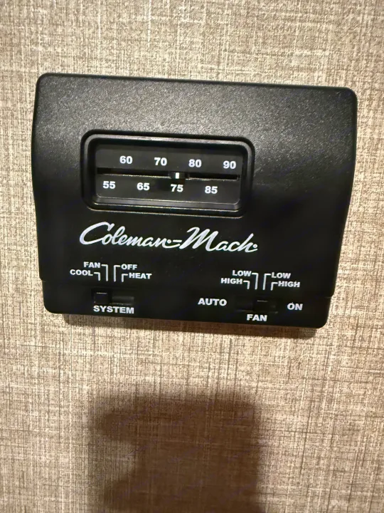 This Coleman-Mach thermostat in an RV rental manages climate control, displaying options for fan, cool, heat, and temperature (currently 75).. Jayco Jay Flight SLX 2023