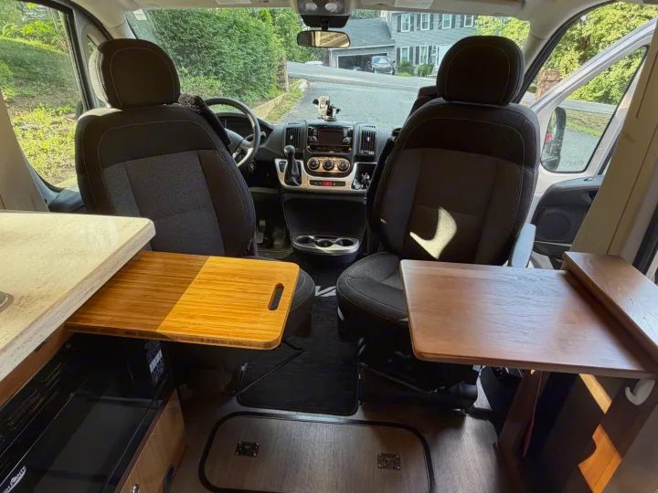 Interior of an rv rental: front cabin with dashboard, comfortable seats, and integrated kitchenette counters.. Winnebago Travato 2016