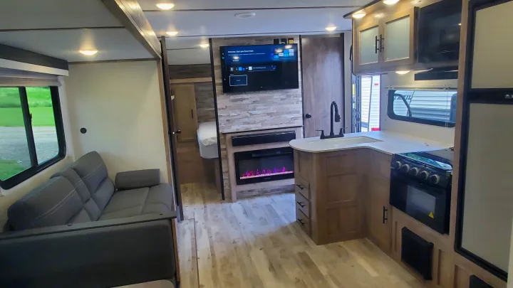 RV rental: Modern interior with full kitchen, comfy sofa, electric fireplace, and mounted TV in the living area.. Gulf Stream Ameri-Lite 2024