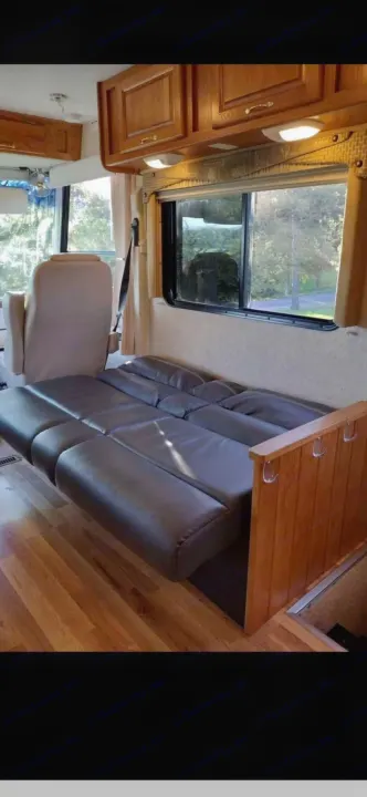 RV rental interior: cozy convertible sofa-bed, wood floor, and scenic window view. Perfect for your next adventure.. Ford 1F6NF3S740A06630 2004