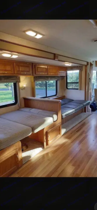 Spacious RV rental interior featuring convertible dinette and lounge seating, wood cabinetry, and scenic windows.. Ford 1F6NF3S740A06630 2004
