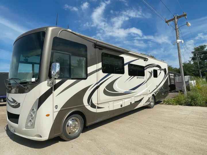 This spacious Windsport Class A motorhome, ideal for your next rv rental adventure, is parked under a clear blue sky.. Thor Windsport 2019