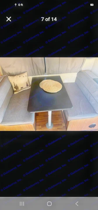 This cozy RV rental dinette features a black table, gray benches, and a rustic bear pillow, perfect for meals on the road.. Thor Majestic 2017