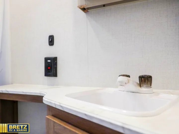 RV rental: Bright bathroom features a white sink with faucet, marbled counter, GFCI outlet, and light switch.. Keystone RV Other 2026