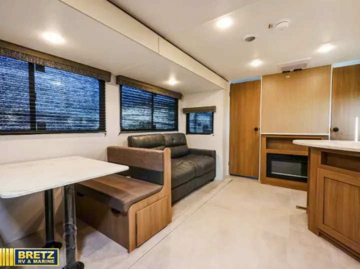 Spacious RV rental interior with a modern dinette, comfortable sofa, and built-in fireplace. Ideal for your next adventure.. Keystone RV Other 2026