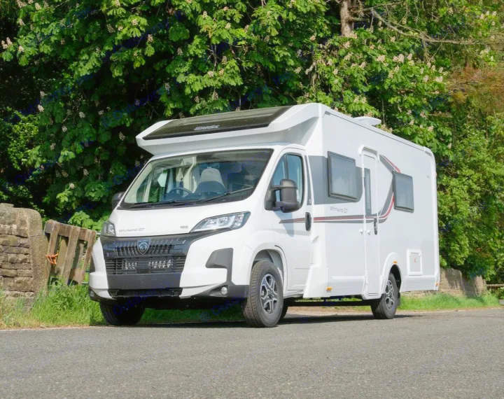 White Elddis Whirlwind GT motorhome, ideal for rv rental, parked on a sunny paved road with lush green trees in the background.. Elddis Whirlwind GT 185 2026