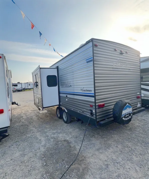 This Coachmen Catalina travel trailer on a gravel lot is perfect for your next rv rental adventure. Explore nature with this camping RV.. Coachmen 5ZT2CALB9LU036851 2020