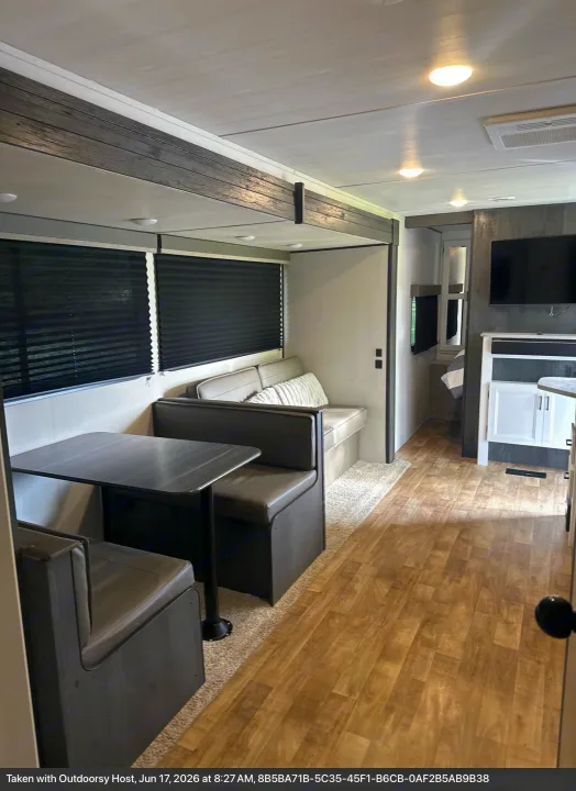 Modern rv rental interior: comfortable dinette, sofa, and wood-look flooring for a relaxing journey.. Keystone RV Hideout 2022